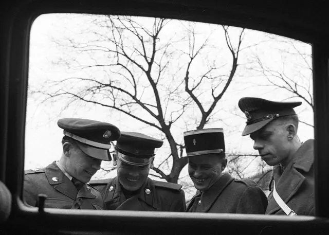 Die Militärpatrouille der vier Besatzungsmächte. Die vier uniformierten Männer mit Kappen (Brustbild) durch ein Autofenster fotografiert