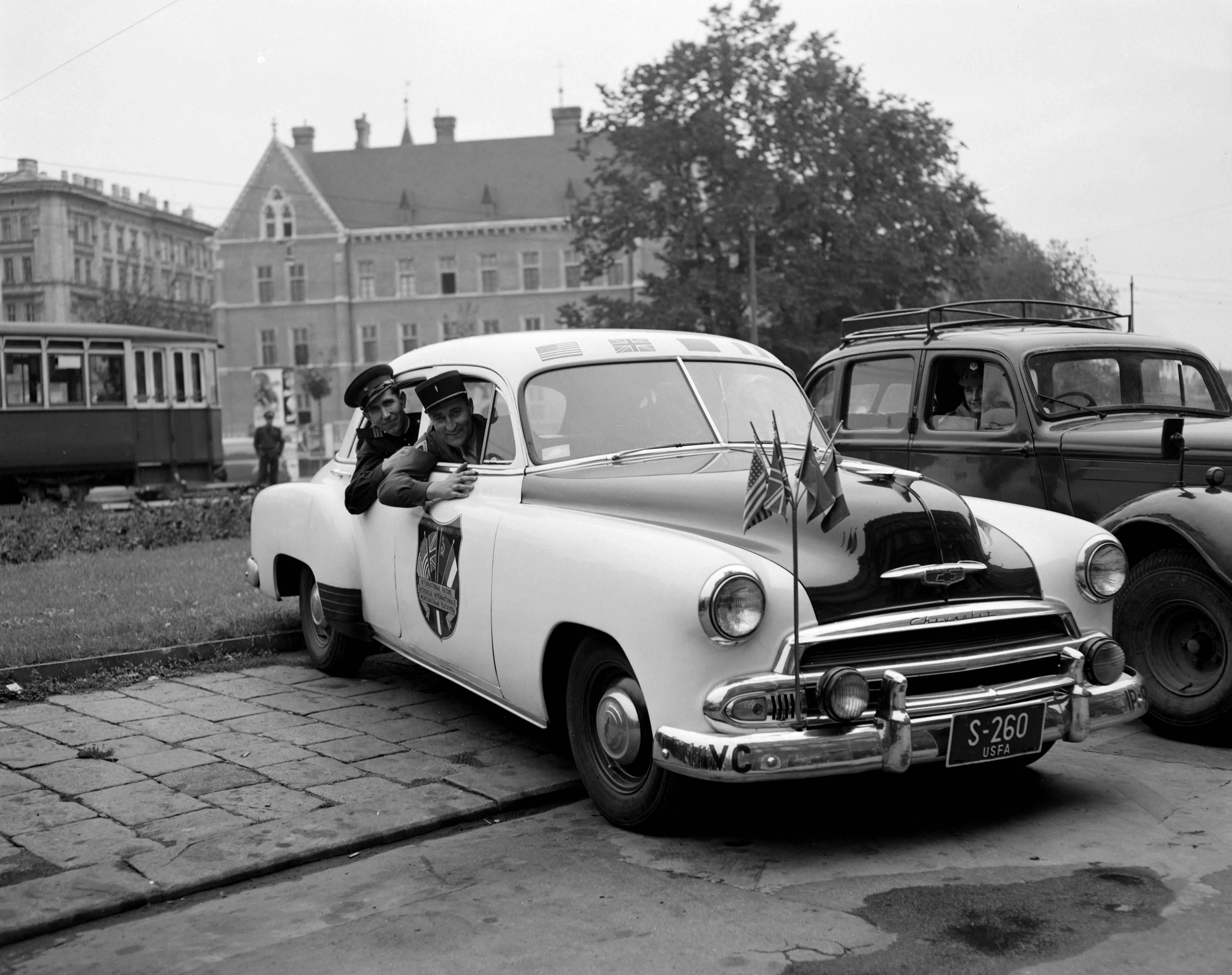Aus weißem "Polizeiauto" mit den vier Fähnchen schauen zwei Soldaten. Ein Russe und ein Franzose.