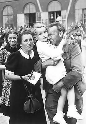 Nicht immer gibt es so ein freudiges Wiedersehen. Der Vater wird am Bahnhof begrüßt. Wien um 1947. Soldat in Uniform nimmt den jungen Sohn in den Arm. Die Mutter steht freudig daneben. 