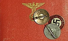 Rotes Büchl mit Reichsadler und einige Parteiabzeichen, teilweise verkehrt.