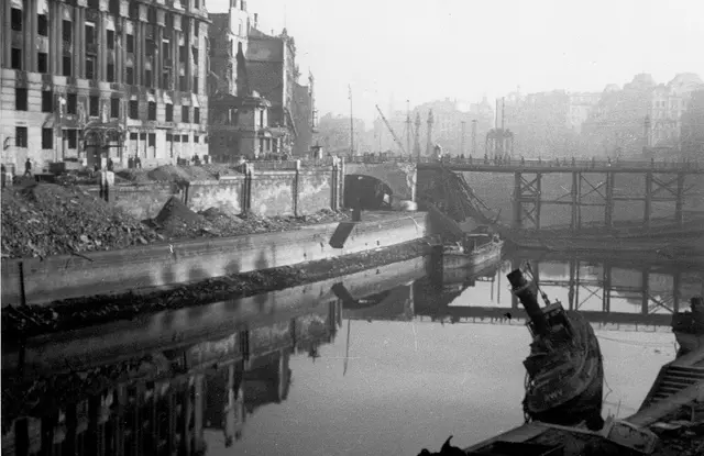 Donaukanal mit kaputtem Schiff und Schutt an den Ufern.