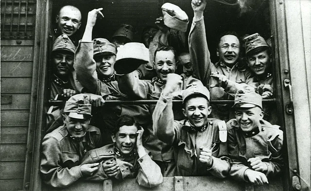 Aufbruch an die Front - Soldaten winken aus Eisenbahn-Güterwagen