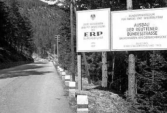 Zwei große Schilder am Straßenrand, der auf beiden seiten bewaldet ist, auf denen die Projektfinanzierung aus dem ERP erklärt wird. (Text am Foto aber kaum lesbar)