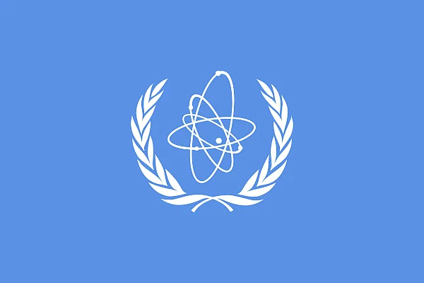 Die hellblaue Flagge der IAEA zeigt ein Atom, umgeben von den UN-typischen Olivenzweigen.