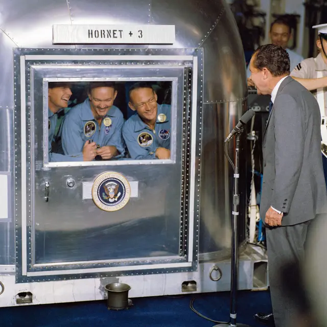 Die Mannschaft von Apollo 11 nach der Rückkehr in Quarantäne - US-Präsident Nixon vor dem Qurantänrebehälter
