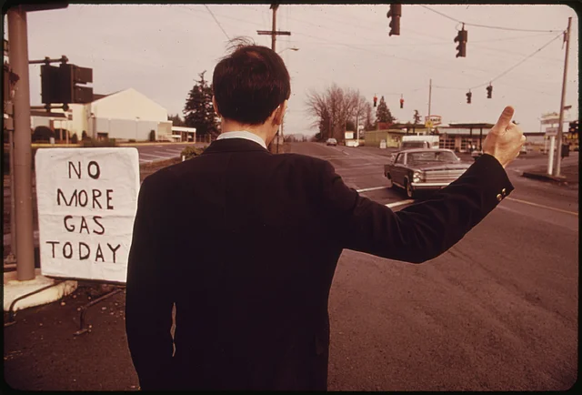 Im Bild ist ein amerikanischer Geschäftsmann im Dezember 1973 beim Autostoppen in die Arbeit zu sehen.Links neben ihm das handgeschriebene Schild: "No More Gas Today"