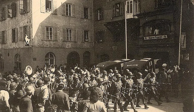 Musikabteilung von US-Soldaten. Auch Schaulustige sind zu sehen.