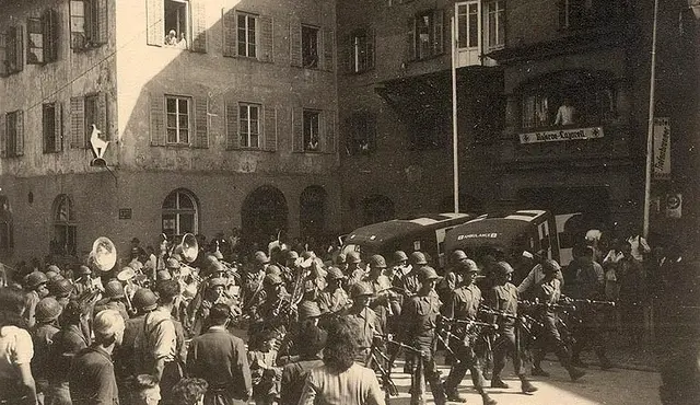 Musikabteilung von US-Soldaten. Auch Schaulustige sind zu sehen.