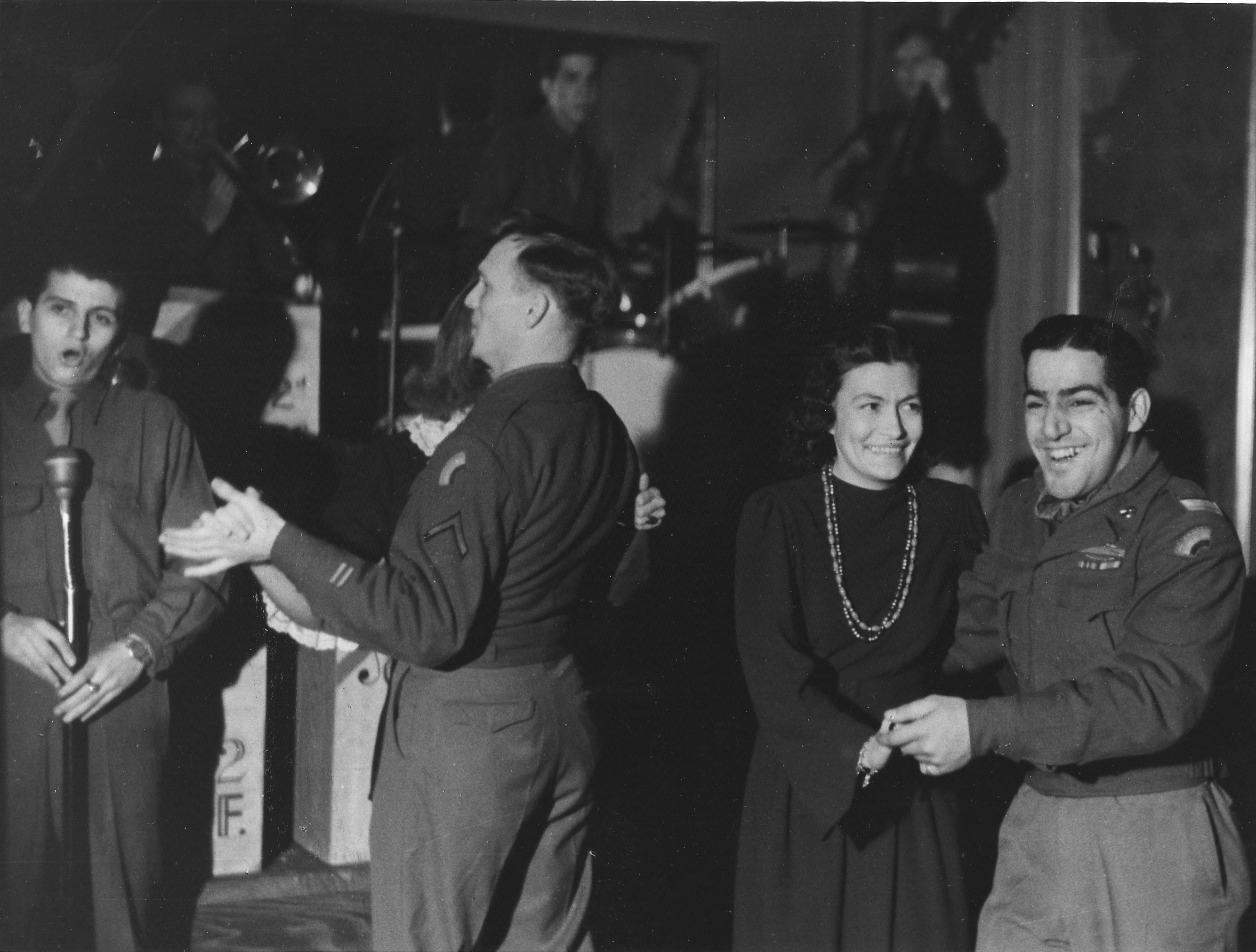 US-Soldaten mit Frauen tanzend auf der Tanzfläche und lachend.