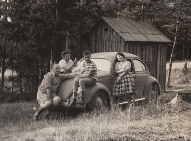Schwarzweißfoto von Familie Tal mit VW Käfer