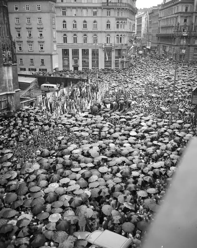 Blick auf den gesteckt vollen Stephansplatz und Stock im Eisen-Platz. Fast alle Leute mit Regenschirmen.
