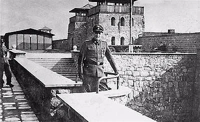 Der Lagerkommandant SS-Sturmbannführer Franz Ziereis vor dem Kommandanturgebäude des KZ Mauthausen, auf der Garagenhofmauer stehend. Zwischen Februar 1939 und April 1944.