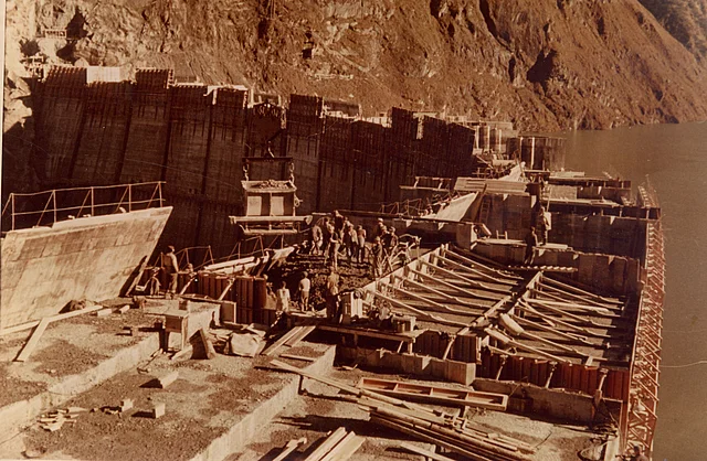 Blick auf die Baustelle für das Kraftwerk Kaprun. Hauptsächlich ist die Staumauer zu sehen auf der Männer betonieren.