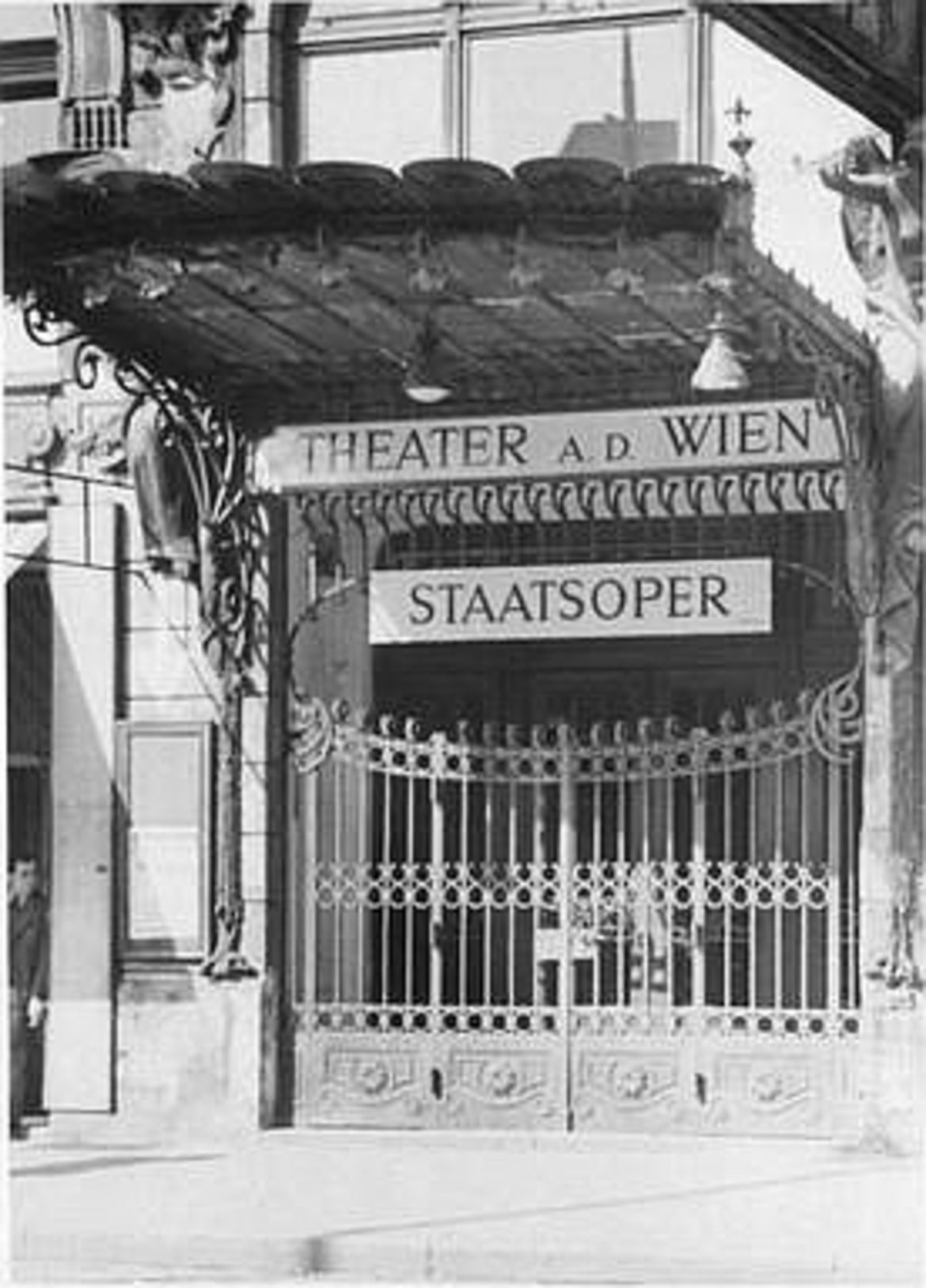 Das Eingangsgittertor des Theaters mit zwei Schildern: "Theater a. d. Wien" und "Staatsoper"