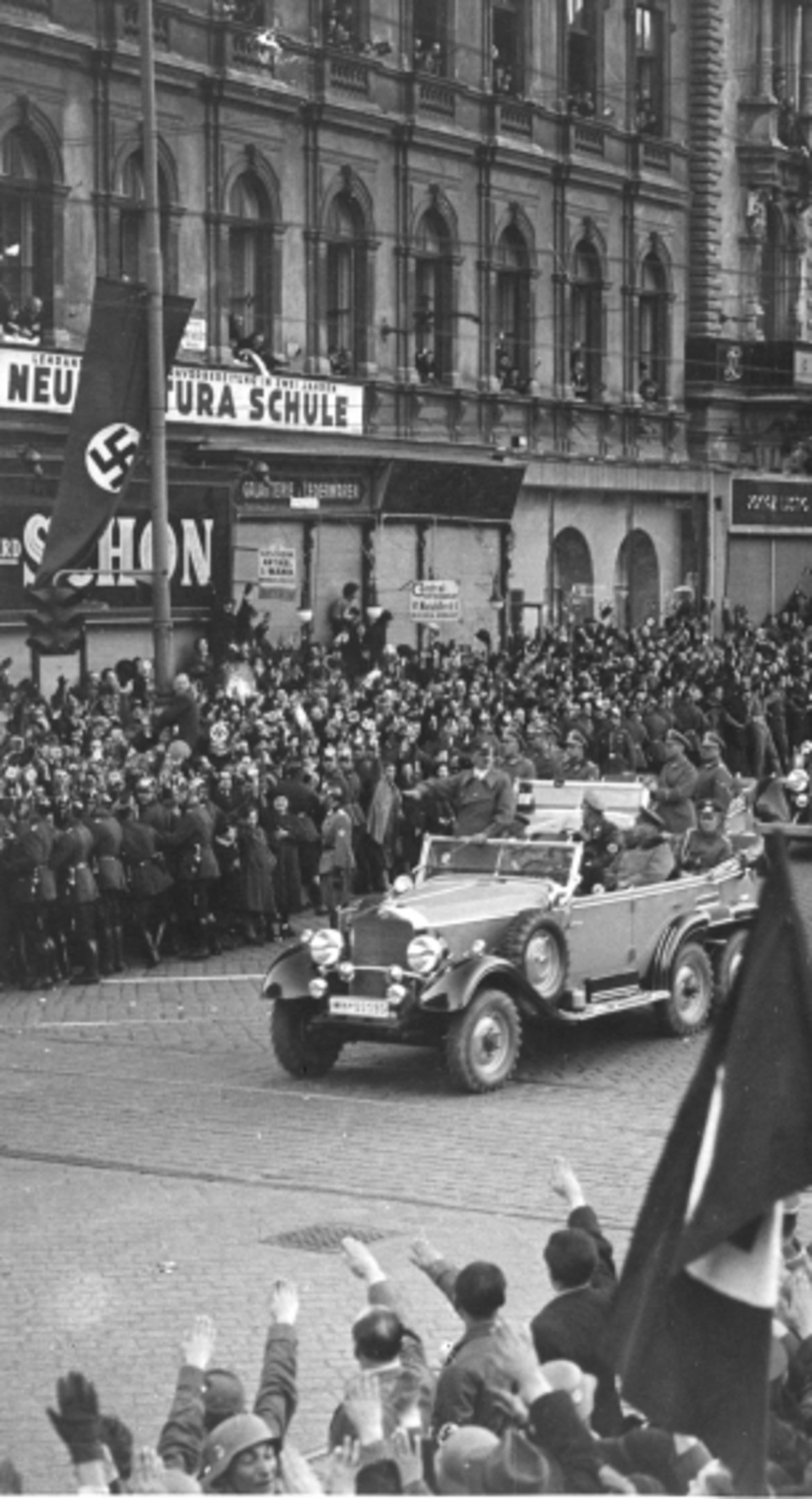 Der Autokonvoi von Adolf Hitler fährt durch eine Menschenmenge in der Mariahilfer Straße.