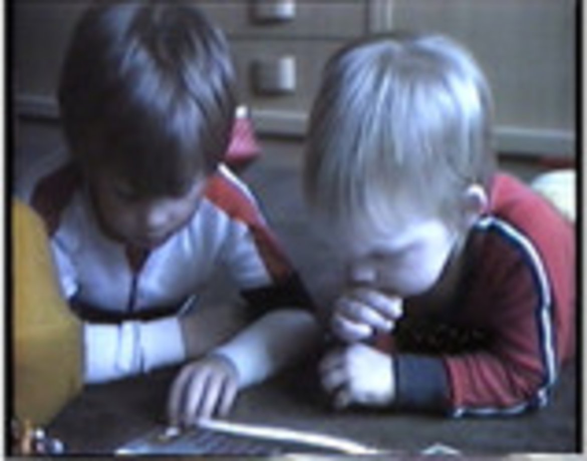 Ein Videostill aus einem Home-Video das zwei Kleinkinder beim Spielen zeigt.