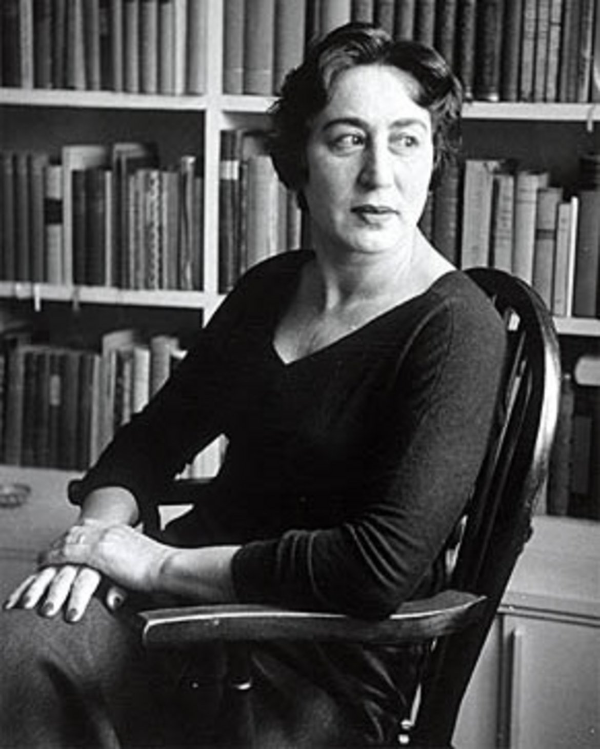 Portraitaufnahme von Hilde Spiel vor einem Bücherregal sitzend.