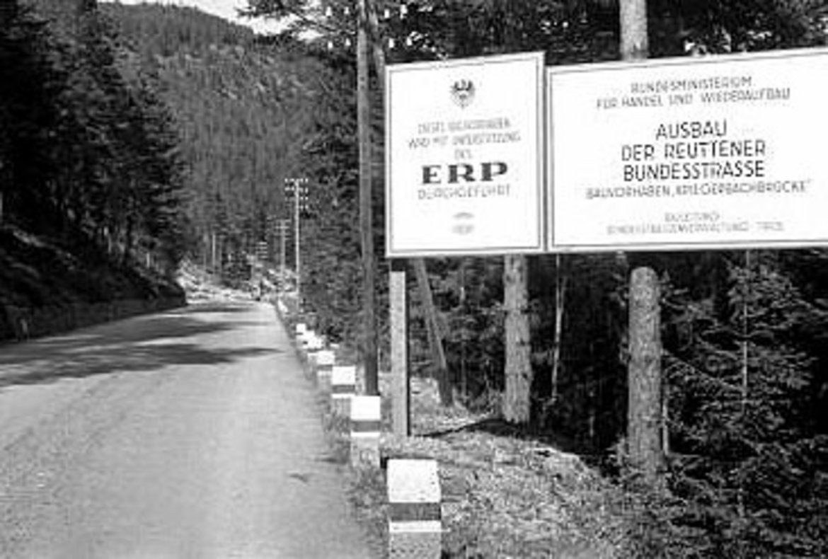 Zwei große Schilder am Straßenrand, der auf beiden seiten bewaldet ist, auf denen die Projektfinanzierung aus dem ERP erklärt wird. (Text am Foto aber kaum lesbar)