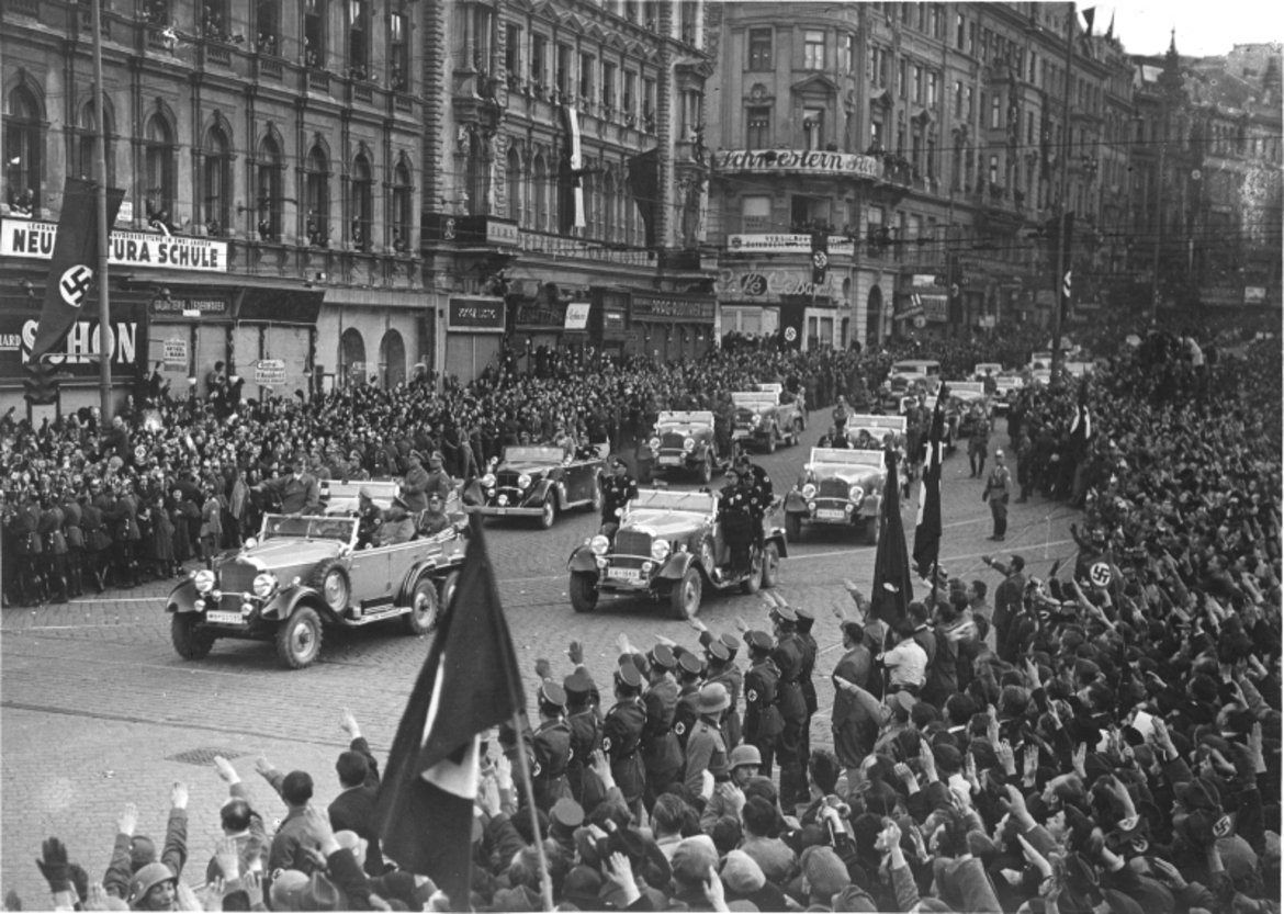Der Autokonvoi von Adolf Hitler fährt durch eine Menschenmenge in der Mariahilfer Straße.